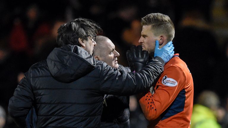 St Mirren goalkeeper Vaclav Hladky is assessed by medics after a firecracker was thrown from the crowd during their game against Celtic