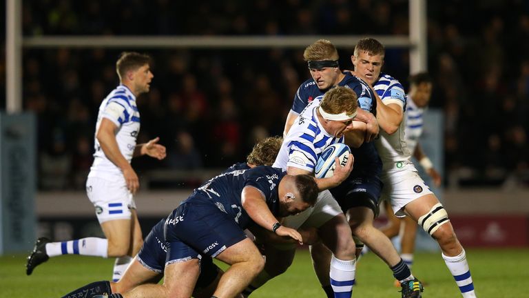 Jacques van Rooyen of Bath Rugby is tackled by Joe Jones and Matt Postlethwaite 