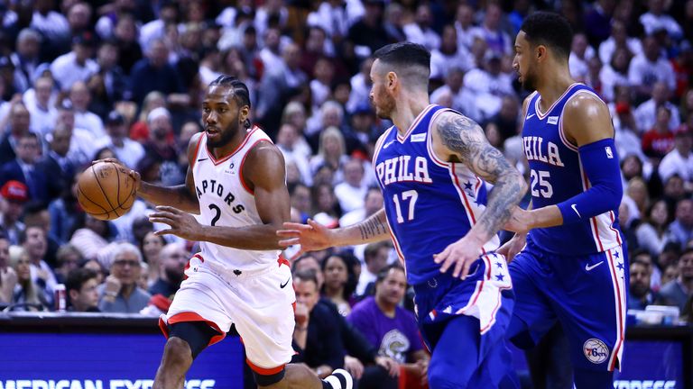Kawhi Leonard #2 of the Toronto Raptors dribbles the ball as JJ Redick #17 and Ben Simmons #25 of the Philadelphia 76ers defend during Game One of the second round of the 2019 NBA Playoffs at Scotiabank Arena on April 27, 2019 in Toronto, Canada. 