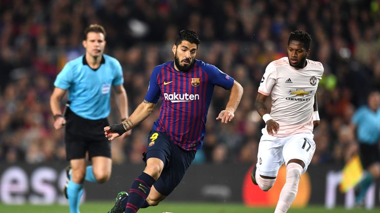 Barcelona's Luis Suarez runs with the ball away from Fred