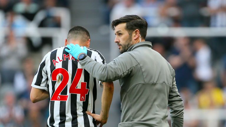 Newcastle United's Miguel Almiron receives medical attention