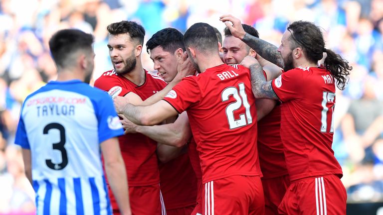 Scott McKenna is mobbed by his teammates after making it 1-0 to Aberdeen.

