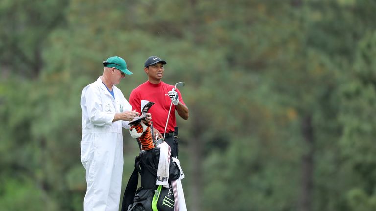 Tiger Woods of the United States waits to play his second shot on the 14th hole alongside caddie Joe LaCava during the final round of the Masters at Augusta National Golf Club on April 14, 2019 in Augusta, Georgia