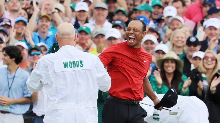 Tiger Woods celebrates with caddie Joe LaCava after putting to win The Masters 2019