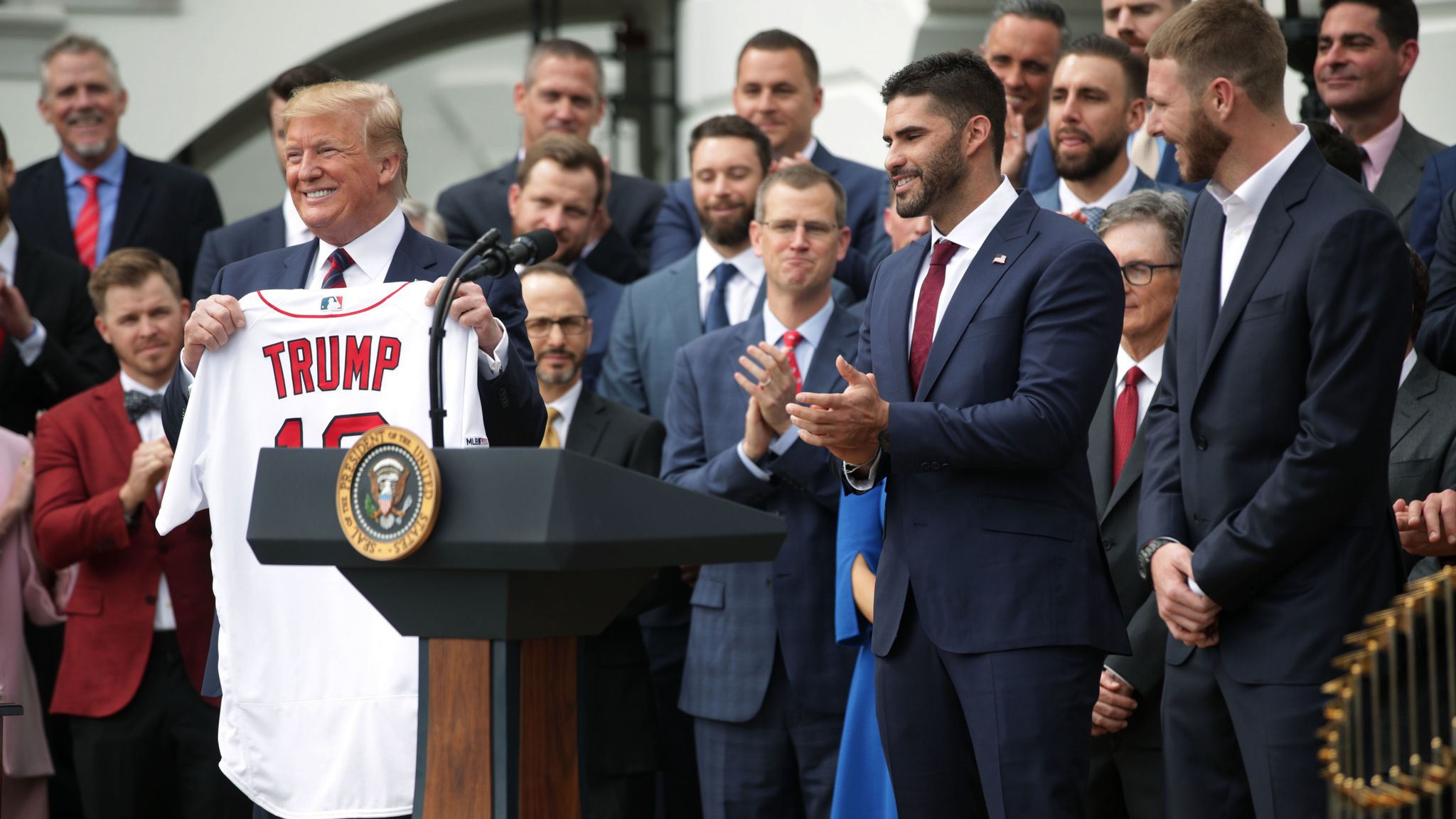 President Donald Trump is presented with a Boston Red Sox baseball team  jersey by Red Sox outfielder J. D. Martinez, during a ceremony on the South  Lawn of the White House in