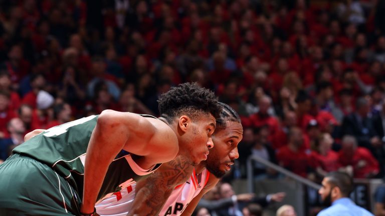 Giannis Antetokounmpo and Kawhi Leonard prepare to contest a rebound