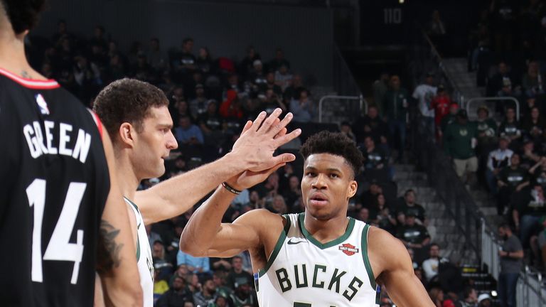 Giannis Antetokounmpo high-fives team-mate Brook Lopez during Milwaukee's Game 2 win over Toronto