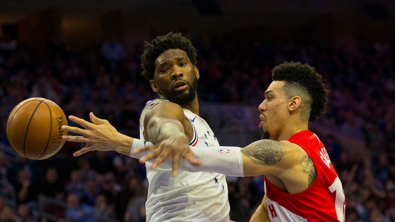 Danny Green throws a pass around Joel Embiid