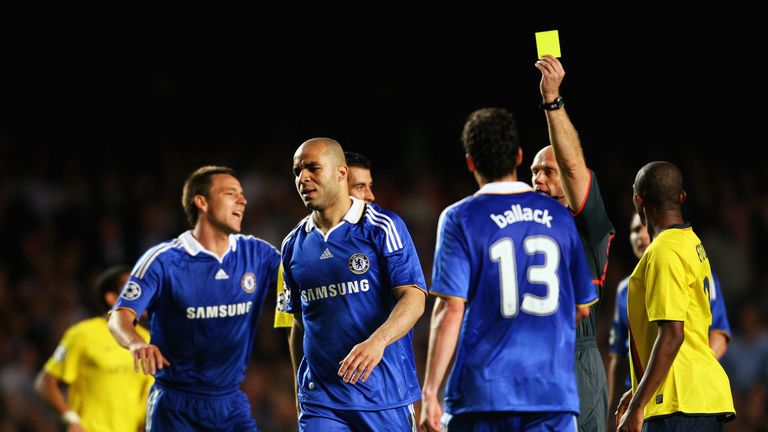 Chelsea defender Alex is shown a yellow card during a a bad-tempered match