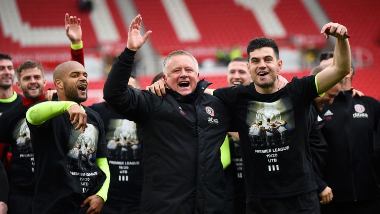 Chris Wilder enjoys the pitchside celebrations with the Blades supporters