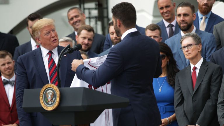 U.S. President Donald Trump is presented with a jersey by right fielder J.D. Martinez as principal owner John W. Henry look on during a South Lawn event to honor the Boston Red Sox at the White House May 9, 2019 in Washington, DC. President Donald Trump hosted the Boston Red Sox to honor their championship of the 2018 World Series.