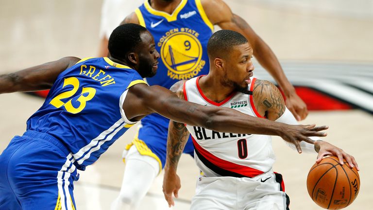 Damian Lillard #0 of the Portland Trail Blazers battles for the ball with Draymond Green #23 of the Golden State Warriors during the first half in game three of the NBA Western Conference Finals at Moda Center on May 18, 2019 in Portland, Oregon. 