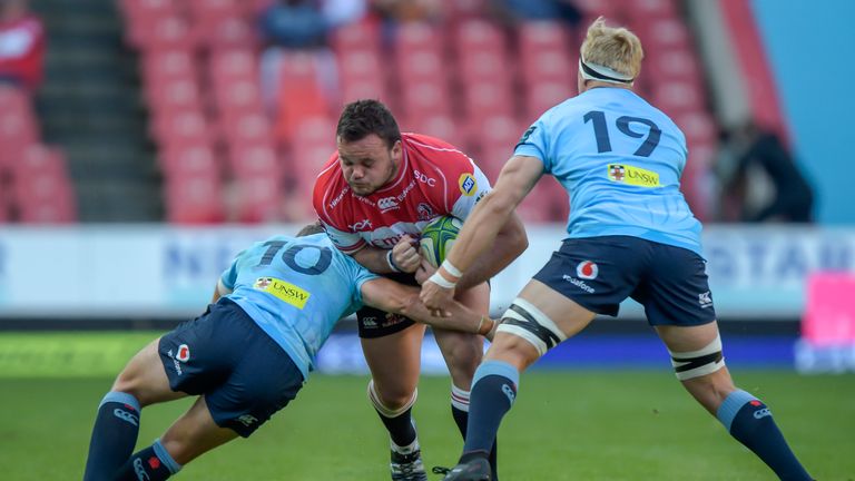 The NSW Waratah's Bernard Foley (L) tackles The Emirates Lions' Dylan Smith (C) during the Super Rugby match, Emirates Lions v NSW Waratahs at the Emirates Airline Park, Johannesburg, on May 11, 2019. (Photo by Christiaan Kotze / AFP) (Photo credit should read CHRISTIAAN KOTZE/AFP/Getty Images)