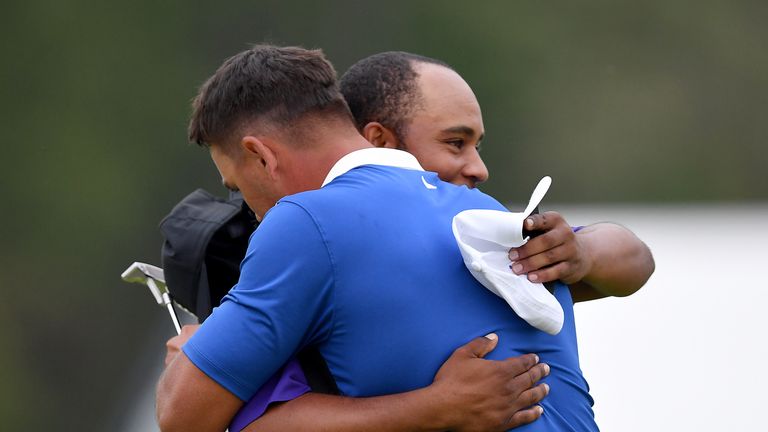 Harold Varner III hugs Brooks Koepka after completing their final rounds at the PGA Championship