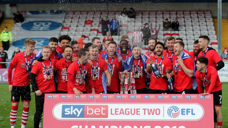 Lincoln City's players celebrate with the league two trophy after the Sky Bet League Two match at Sincil Bank, Lincoln. PRESS ASSOCIATION Photo. Picture date: Saturday May 4, 2019. See PA story SOCCER Lincoln. Photo credit should read: Richard Sellers/PA Wire. RESTRICTIONS: EDITORIAL USE ONLY No use with unauthorised audio, video, data, fixture lists, club/league logos or "live" services. Online in-match use limited to 120 images, no video emulation. No use in betting, games or single club/league/player publications.