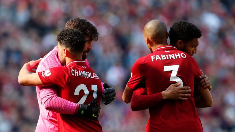 Liverpool players Alex Oxlade-Chamberlain, Alisson Becker, Fabinho and Joe Gomez embrace at full-time after Liverpool miss out in the Premier League title