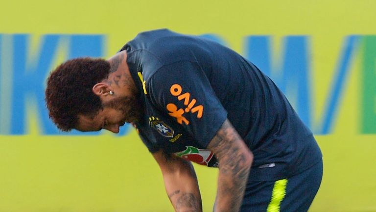 Neymar grabs his knee during Brazil training