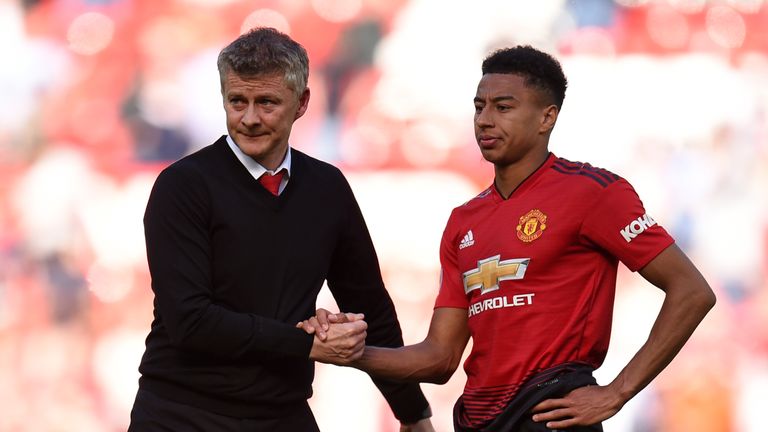 Manchester United's English midfielder Jesse Lingard (R) shakes hands with Manchester United's Norwegian manager Ole Gunnar Solskjaer (L) on the pitch after the English Premier League football match between Manchester United and Cardiff City at Old Trafford in Manchester, north west England, on May 12, 2019. - Cardiff won the game 2-0.