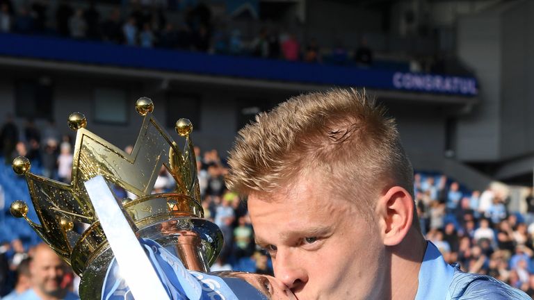 Oleksandr Zinchenko kisses the Premier League trophy after Manchester City retain the title