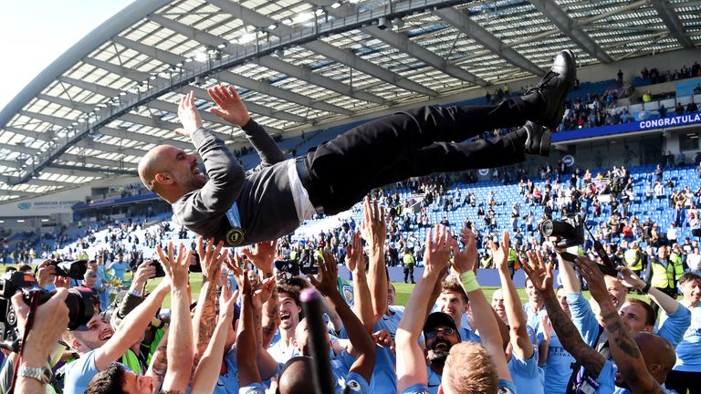 BRIGHTON, ENGLAND - MAY 12: Manchester City players throw Josep Guardiola, Manager of Manchester City in the air as they celebrate winning the Premier League title following the Premier League match between Brighton & Hove Albion and Manchester City at American Express Community Stadium on May 12, 2019 in Brighton, United Kingdom. (Photo by Mike Hewitt/Getty Images)