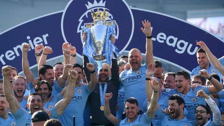 Pep Guardiola lifts the Premier League trophy after Manchester City retain the title
