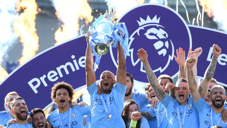 Vincent Kompany lifts the Premier League trophy after Manchester City are crowned back-to-back champions