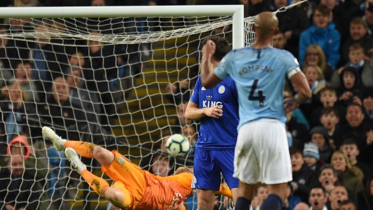 Manchester City's Belgian defender Vincent Kompany (R) watches as his shot beats Leicester City's Danish goalkeeper Kasper Schmeichel (L) to score the opening goal during the English Premier League football match between Manchester City and Leicester City at the Etihad Stadium in Manchester, north west England, on May 6, 2019.