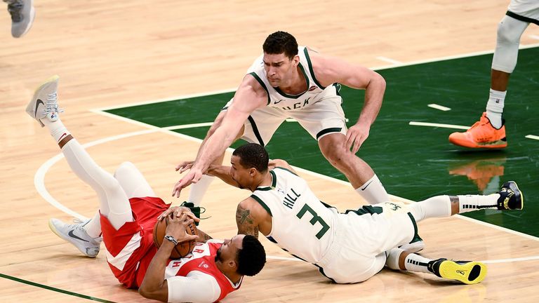 Brook Lopez and George Hill try to get the ball off Norman Powell during a bruising Game 5