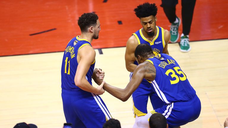 Kevin Durant is helped to his feet by team-mates Kaly Thompson and Quinn Cook