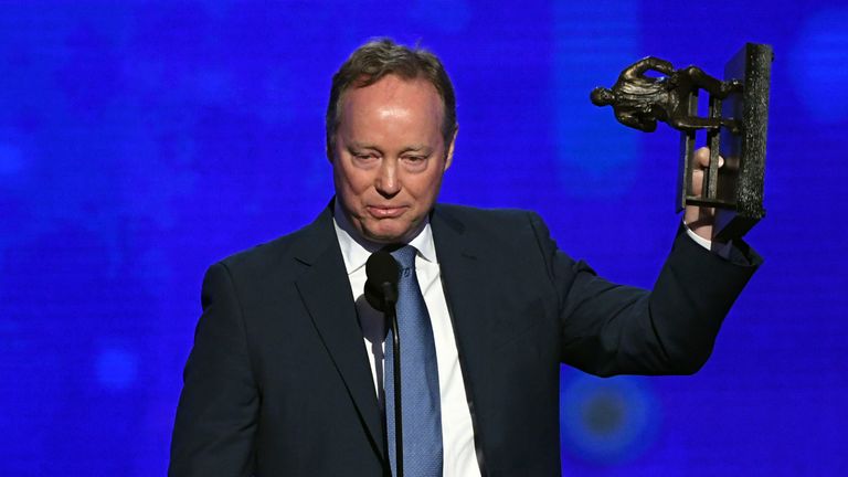 Mike Budenholzer raises his Coach of the Year trophy at the NBA Awards