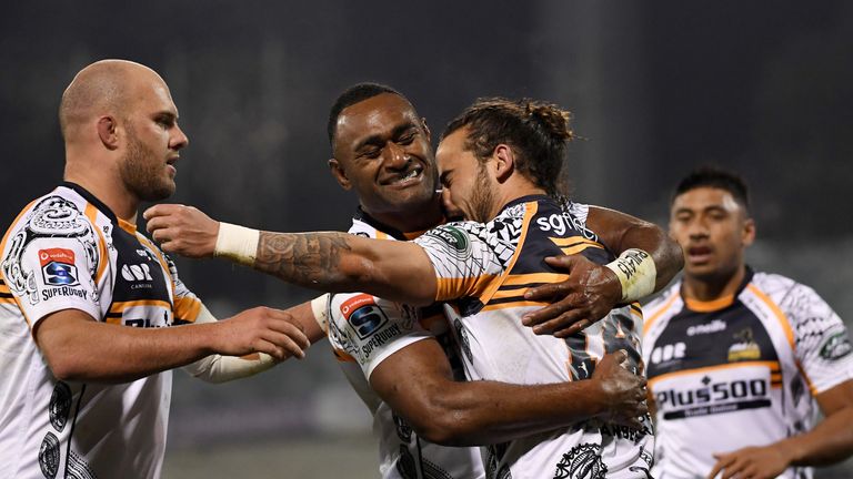 Andy Muirhead is mobbed after scoring for the Brumbies against the Reds