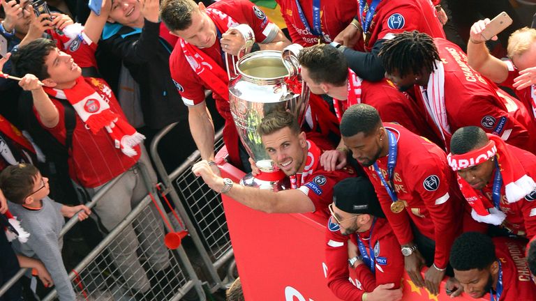 Liverpool players show off the Champions League trophy during a packed-out victory parade back on Merseyside.