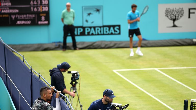 Nick Kyrgios of Australia looks over a fence to watch a game on court one during a change of ends during his First Round Singles Match against Roberto Carballes Baena of Spain during day Four of the Fever-Tree Championships at Queens Club on June 20, 2019 in London, United Kingdom.