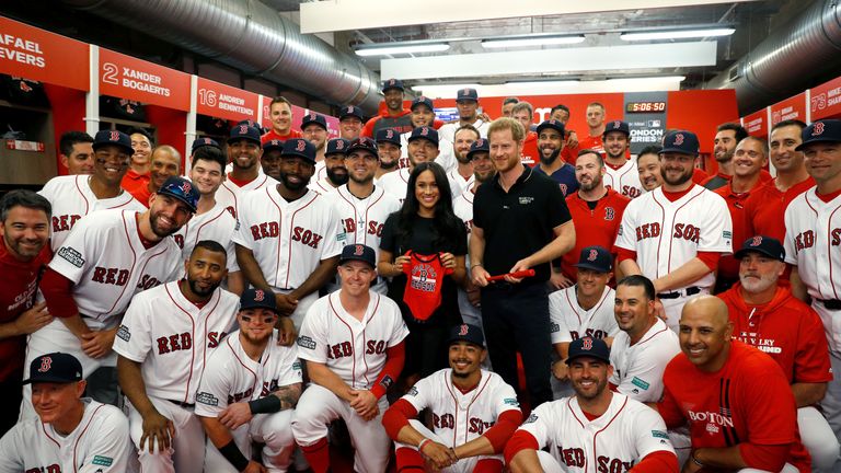 Prince Harry and Meghan, Duchess of Sussex pose for a picture with players of the Boston Red Sox.