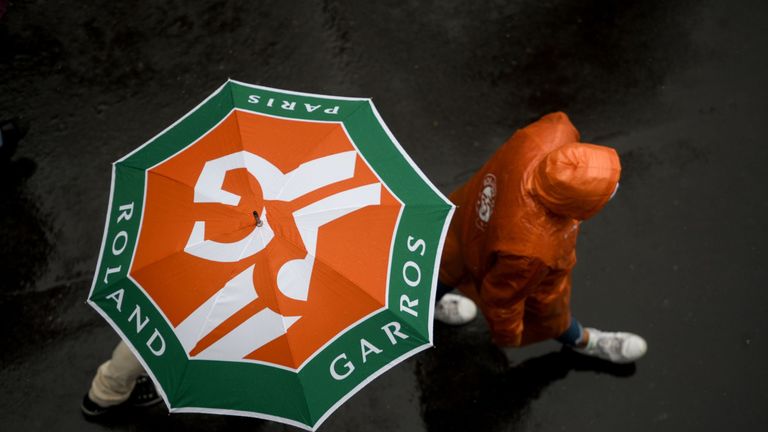 People hold their umbrella as rain falls on day eleven of The Roland Garros 2019 French Open tennis tournament in Paris on June 5, 2019. 