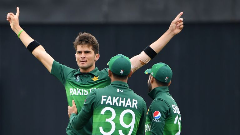 Pakistan's Shaheen Afridi (L) celebrates with team-mates Fakhar Zaman and Shadab Khan after the dismissal of New Zealand's Colin Munro