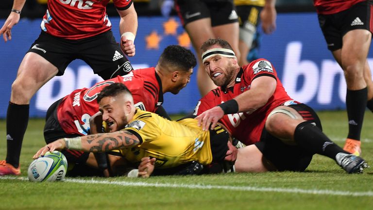 Hurricanes' TJ Perenara (L) scores a try with teammate Gareth Evans (R) as Crusaders' Richie Mo'unga (C) reacts during the Super Rugby semi-final match between New Zealand's Crusaders and Hurricanes in Christchurch on June 29, 2019. (Photo by Marty MELVILLE / AFP) (Photo credit should read MARTY MELVILLE/AFP/Getty Images)