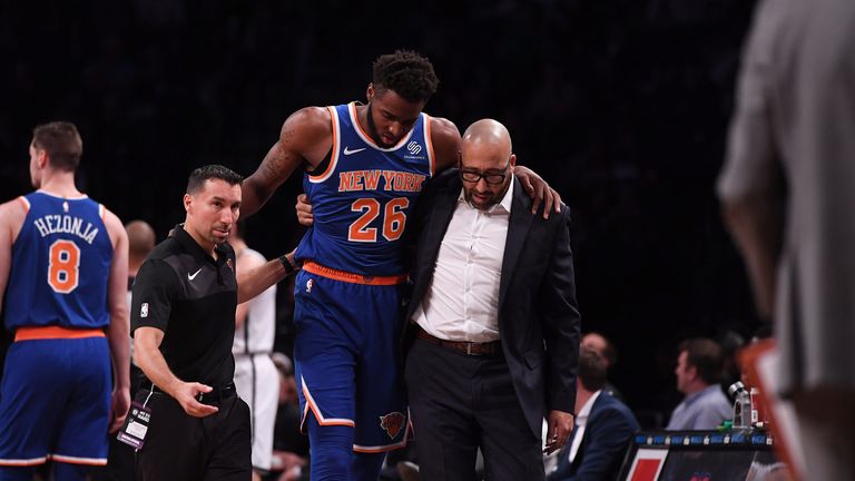 Knicks center Mitchell Robinson is helped from the court