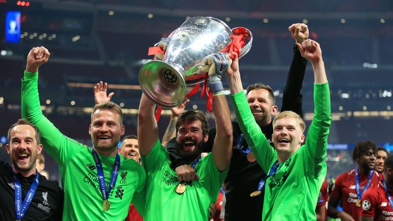 Liverpool goalkeepers, Simon Mignolet, Alisson Becker and Caoimhin Kelleher celebrate with the Champions League trophy 
