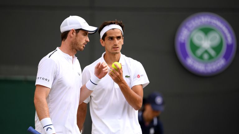 Andy Murray of Great Britain speaks with playing partner Pierre-Hughes Herbert of France during their Men's Doubles first round match against Marius Copil of Romania and Ugo Humbert of France during Day four of The Championships - Wimbledon 2019 at All England Lawn Tennis and Croquet Club on July 04, 2019 in London, England