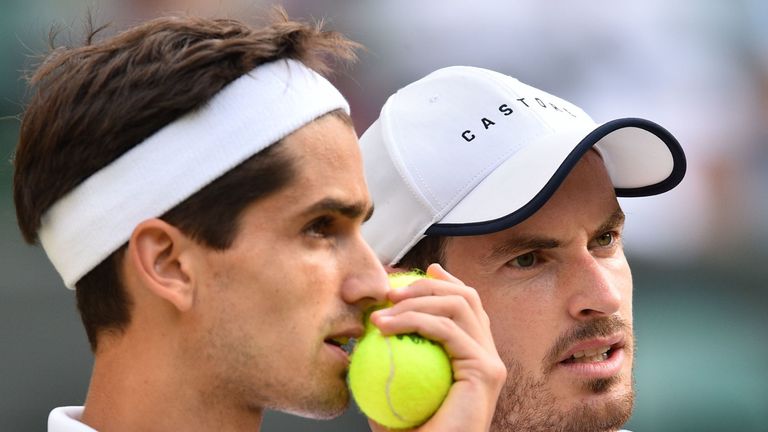 Andy Murray (R) talks with Pierre-Hugues Herbert during their men's doubles second round match on the fourth day of the 2019 Wimbledon Championships at The All England Lawn Tennis Club in Wimbledon, southwest London, on July 4, 2019