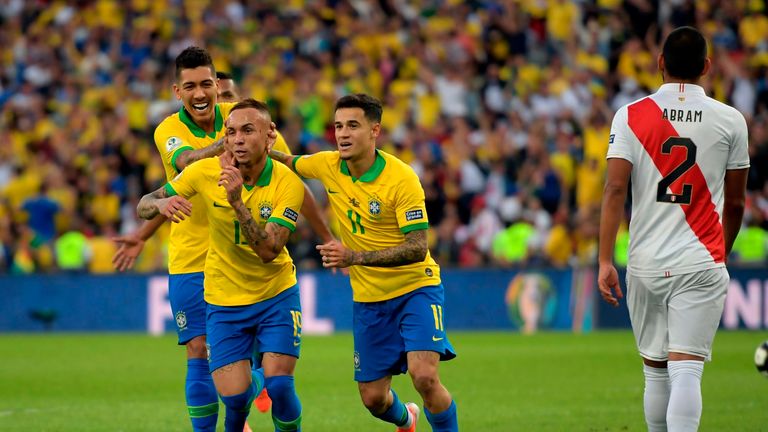 Everton (C) celebrates with Brazil team-mates Roberto Firmino (L) and Philippe Coutinho after scoring against Peru
