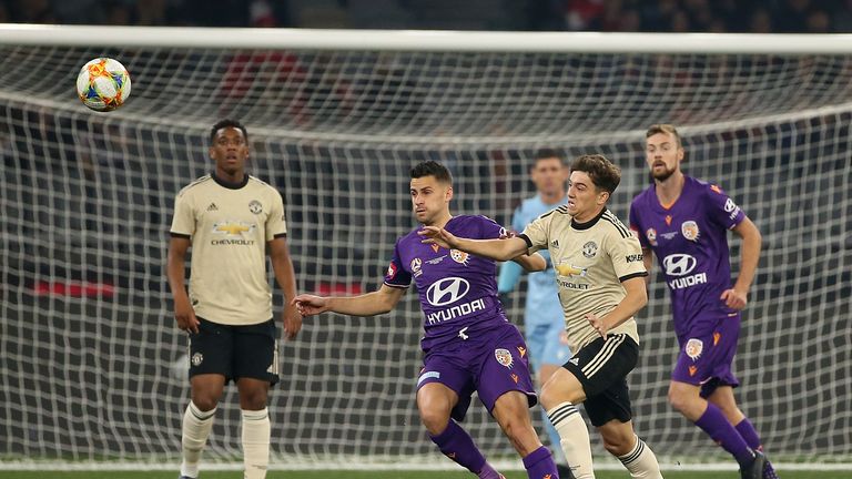 Perth Glory's Joel Chianese and Man Utd's Daniel James contest for the ball