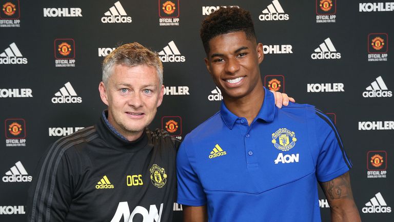 Marcus Rashford poses with Manchester United manager Ole Gunnar Solskjaer after signing a new deal