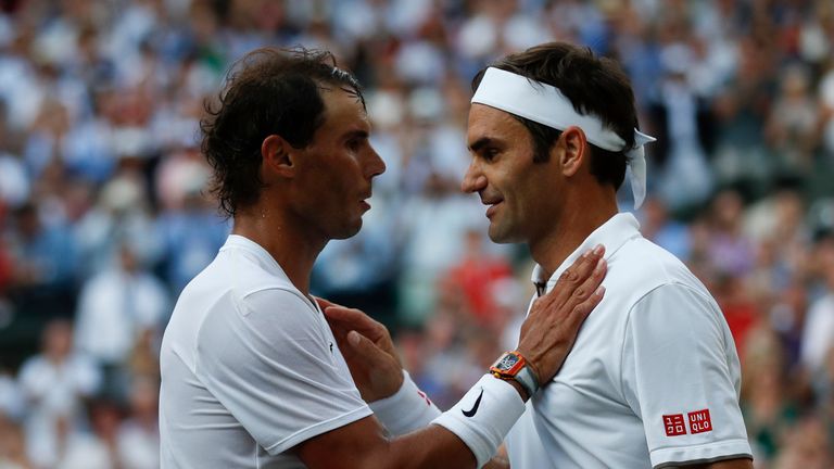 Switzerland's Roger Federer (R) shakes hands and embraces Spain's Rafael Nadal (L) after Federer won their men's singles semi-final match on day 11 of the 2019 Wimbledon Championships at The All England Lawn Tennis Club in Wimbledon, southwest London, on July 12, 2019. (Photo by Adrian DENNIS / POOL / AFP) / RESTRICTED TO EDITORIAL USE