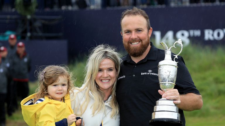 Shane Lowry holds the Claret Jug as he celebrates with his wife Wendy Honner and their daughter Iris