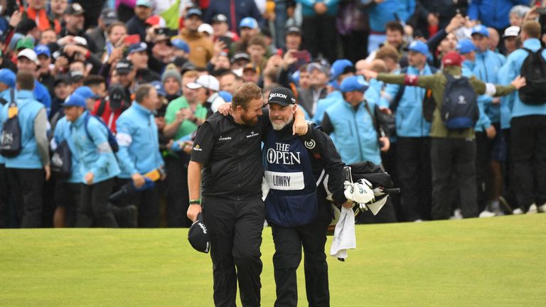 Shane Lowry breaks through the huge crowds on the 18th hole and celebrates with his caddie Brian Martin