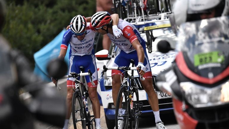 France's Thibaut Pinot (L) is comforted by a teammate as he stops, forced to quit the Tour 