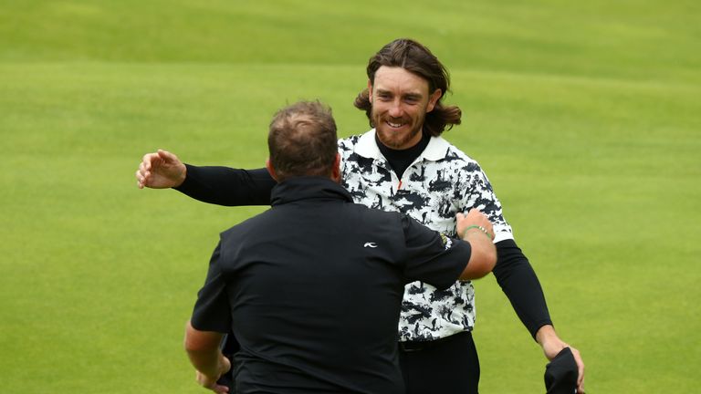 Tommy Fleetwood hugs champion Shane Lowry on the 18th green