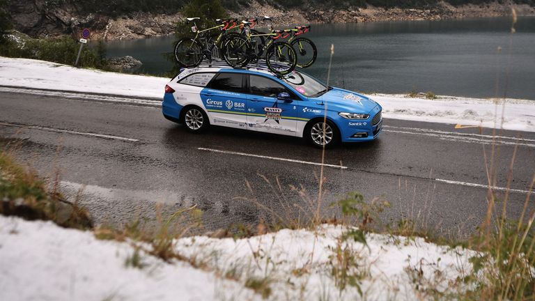 A cycling team car pass by snowcovered roadside after the race was stopped due to bad weather conditions in the last 20 kilometers during the nineteenth stage of the 106th edition of the Tour de France cycling race between Saint-Jean-de-Maurienne and Tignes, in Tignes, on July 26, 2019. (Photo by Marco Bertorello / AFP) (Photo credit should read MARCO BERTORELLO/AFP/Getty Images)